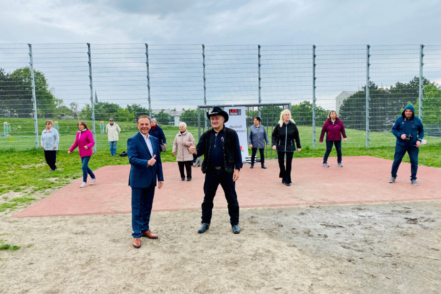 Bezirksvorsteher Gerald Bischof mit Günter Haas vor der Linedancer Gruppe im Park