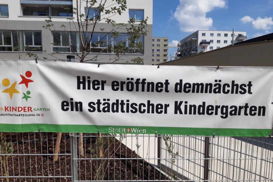 Transparent hängt auf einem Zaun mit dem Text Hier eröffnet demnächst ein städtischer Kindergarten