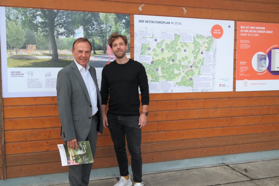 2 Personen stehen vor einer Wand mit Ausstellungstafeln