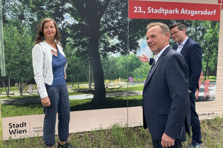 3 Personen vor einer Plakatwand, die den künftigen Park zeigt