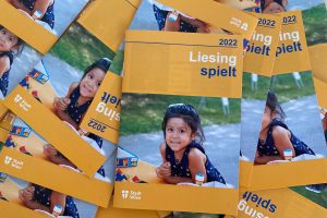 mehrere gelbe Ferienspielhefte liegen wild durcheinander