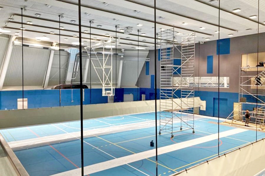 Blick auf das Innenleben der neuen Halle mit blauem Belag und diversen Baugerüsten