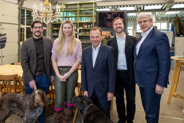 5 Personen Im Verkaufsraum der Hunters Lodge: (v.l.n.r.) Arian Saber Zaeimian, Karoline Kronsteiner, Gerald Bischof, Markus Fiala (WIR23), Matthias Schiffer (WKO) im Vordergrund 2 Hunde