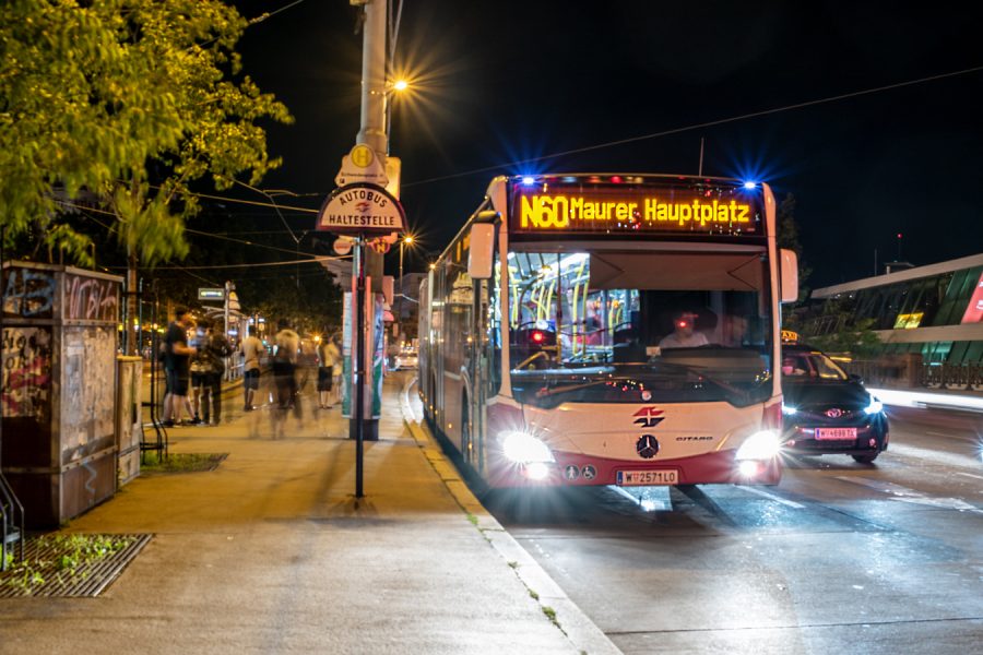 Nachtbus N 60 der Wiener LInien, bei Nacht in einer Station stehend, links im Bild Blätter eines Baumes