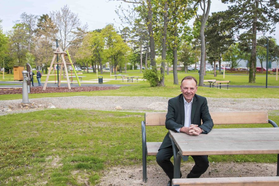 Gerald Bischof sitzt an einem Tisch, im Hintergrund der neue Park