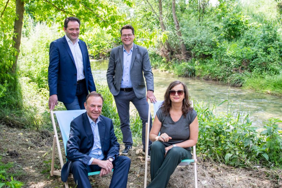 Bundesminister Totschnig, Stadträtin Ulli Sima, Stadtrat Jürgen Czernohorsky und Bezirksvorsteher Gerald Bischof auf und hinter Liegestühlen, rechts davon der Liesingbach, im Hintergrund viele Büsche und Bäume