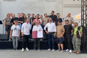 Gruppe von Menschen steht vor einer Bühne