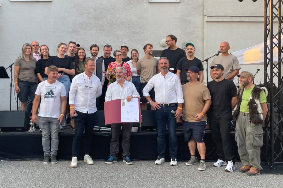 Gruppe von Menschen steht vor einer Bühne